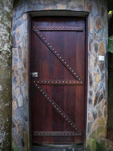 a large wooden door in a stone wall at Pu Luong Jungle Lodge in Pu Luong