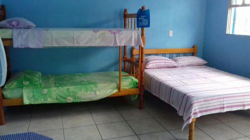 een slaapkamer met 2 stapelbedden en een blauwe muur bij Residencial Água Azul in Capão da Canoa