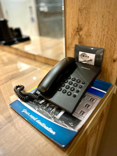 a black phone sitting on top of a desk at Hotel Borea in Peje