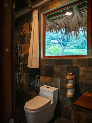 a bathroom with a toilet and a window at Pu Luong Jungle Lodge in Pu Luong