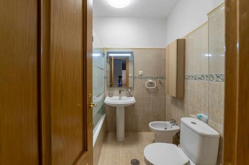 uma casa de banho com um WC branco e um lavatório. em Lormar Apartamento em Zamora