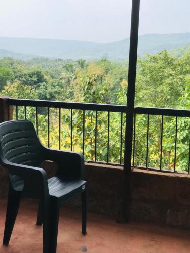 a chair sitting on top of a balcony with a view at Rohan Homestay By Traviget Hospitality, Dapoli-Konkan in Harnai