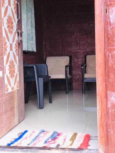 an open door to a room with two chairs and a rug at Rohan Homestay By Traviget Hospitality, Dapoli-Konkan in Harnai