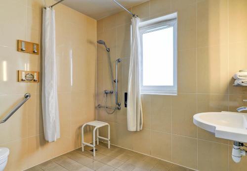y baño con ducha y lavamanos. en B&B HOTEL Dijon Nord Zénith, en Dijon