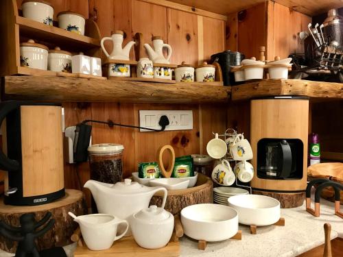 a kitchen with wooden shelves filled with cups and dishes at Chalet Shanag Manali in Manāli