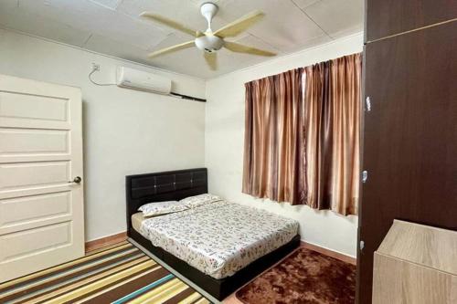 - une chambre avec un lit et un ventilateur de plafond dans l'établissement K & J Homestay — Seremban Jaya 7, à Seremban