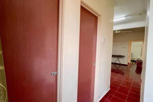 Cette chambre est dotée d'une porte rouge et de carrelage rouge. dans l'établissement K & J Homestay — Seremban Jaya 7, à Seremban