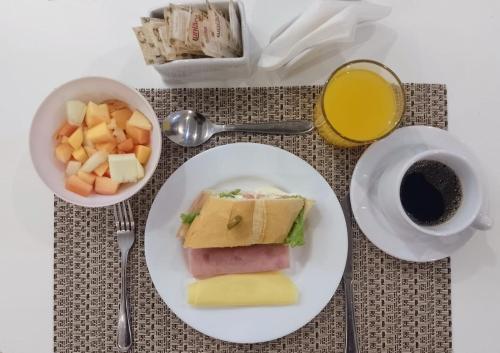 a table with a plate of food and a cup of coffee at Astor Hotel in Bauru