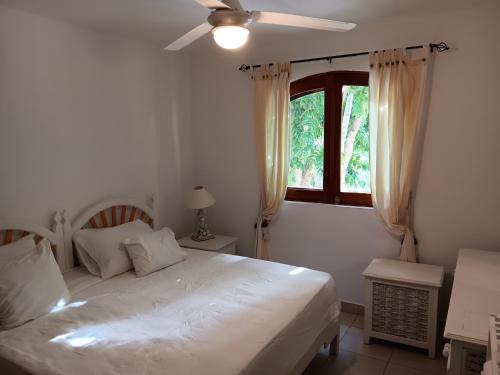 a bedroom with a white bed and a window at Newly Renovated Seaside Oasis at Bonita Village in Las Terrenas