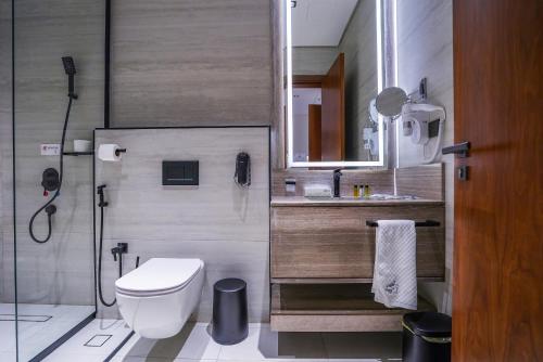 a bathroom with a toilet and a sink and a shower at Vivian Park El Raeid Hotel in Riyadh