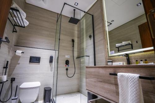 a bathroom with a shower with a toilet and a sink at Vivian Park El Raeid Hotel in Riyadh