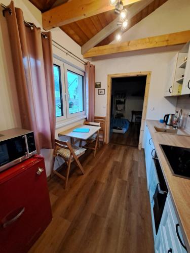 a kitchen and dining room with a table and a counter at Útulný apartmán in Bohatice