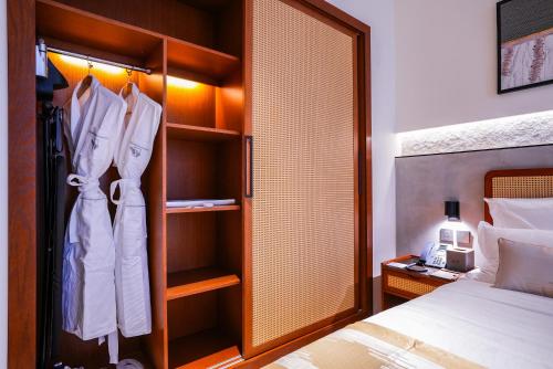 a bedroom with a bed and a closet with white clothes at Vivian Park El Raeid Hotel in Riyadh