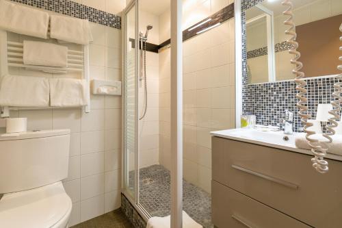 uma casa de banho com um chuveiro, um WC e um lavatório. em Hôtel Dijon Sud Longvic em Dijon