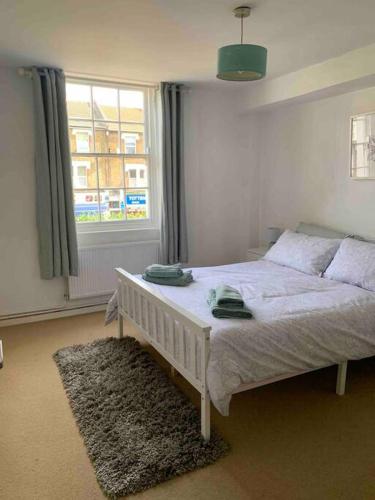 a bedroom with a white bed and a window at Large Apartment - 20 mins to the City in London
