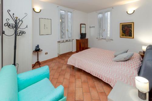 1 dormitorio con 1 cama y 1 sofá azul en Le Ruote, en Vezzano sul Crostolo