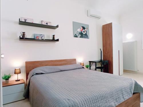 sypialnia z łóżkiem i półkami na ścianie w obiekcie Le Stanze del Corso w mieście Ascoli Piceno
