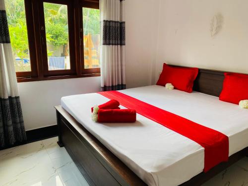 a bedroom with a large bed with red pillows at The Kingslayer Resort in Negombo