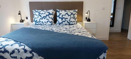 1 dormitorio con 1 cama azul y blanca y 2 mesitas de noche en Vv Casa Zoila, en Vallehermoso