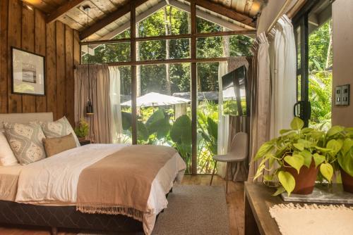 a bedroom with a bed and a large window at KAÑIK APART HOTEL in Puerto Viejo