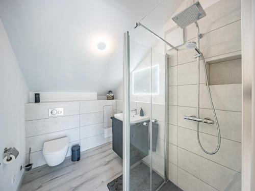 a bathroom with a shower and a toilet and a sink at Dachgeschoss-Ferienwohnung in Sonthofen