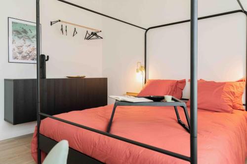 a bedroom with a canopy bed with a desk on it at Appartement T3 la perle verte in Agde