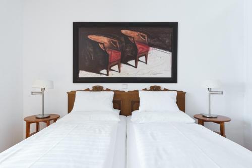 オーバータウエルンにあるAlpina Holiday Living Apartmentsの赤い椅子2脚付きの客室内のベッド2台