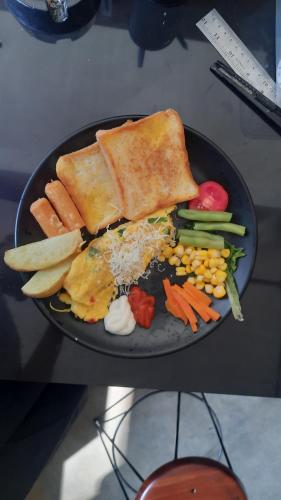 a plate of food with bread and vegetables on a table at Bromo Dormitory & Camp in Bromo