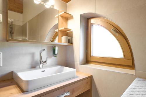 uma casa de banho com um lavatório branco e uma janela em Alpina Holiday Living Apartments em Obertauern