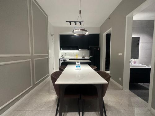 a dining room and kitchen with a white table and chairs at The Axon Suites Bukit Bintang KLCC By SKYSCRAPER in Kuala Lumpur