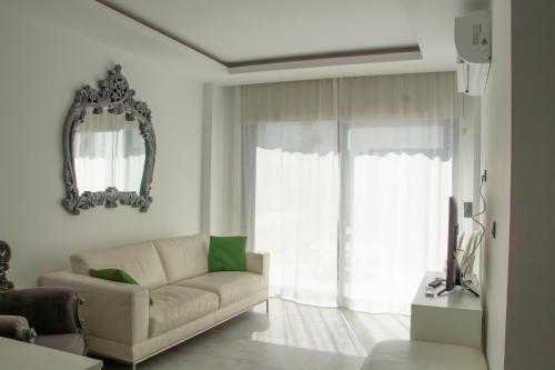 a living room with a couch and a mirror at Seaside Serenity in Bodrum: Luxury Retreat w View in Turgutreis