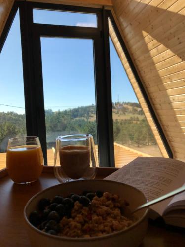 a bowl of food on a table with two glasses of orange juice at Azalea Chalet in Divčibare