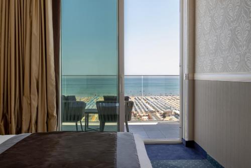 a bedroom with a large window with a view of a city at Hotel Sporting in Rimini