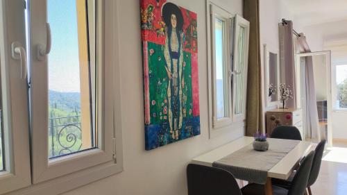 a dining room with a table and a painting on the wall at Villa Amaryllis in Paleokastritsa