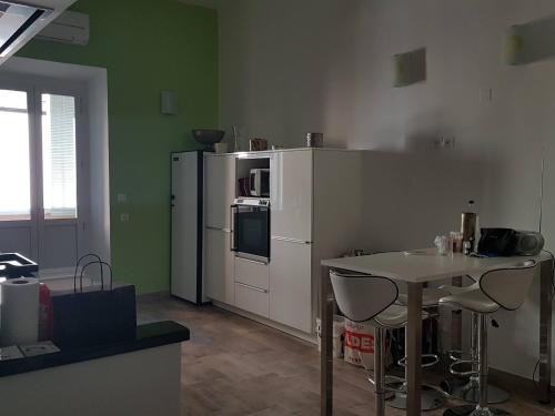 Il comprend une cuisine équipée d'un réfrigérateur blanc et d'une table avec des chaises. dans l'établissement Grand Standing, à Ajaccio