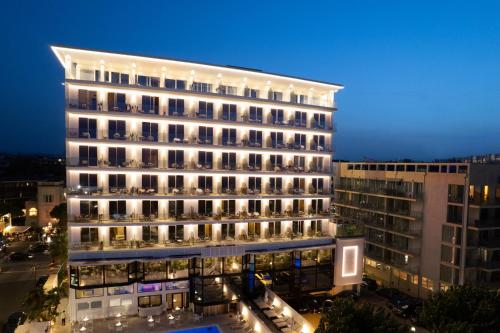 a large building with lights in a city at night at Hotel Sporting in Rimini