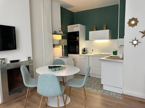 - une cuisine avec une table et des chaises blanches dans la chambre dans l'établissement Centre ville proche des Halles de Tours, à Tours
