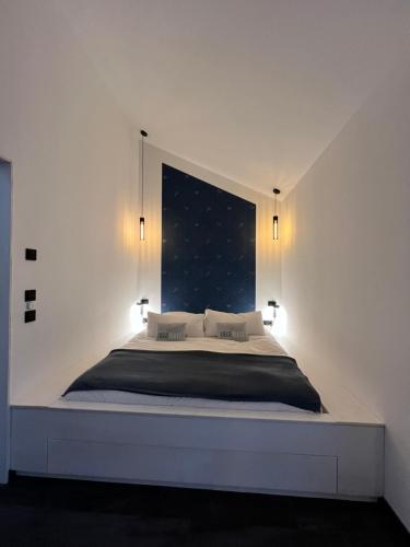 a bedroom with a large bed with two lights on it at Sonnendeck Chalet in Großkoschen