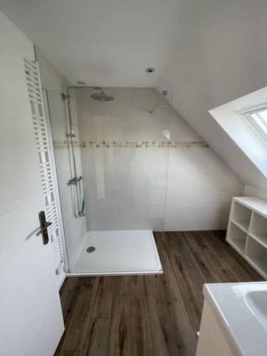 une salle de bain blanche avec une douche et un lavabo dans l'établissement Ty Glas charmante maison 200 m de la plage, à Ploudalmézeau