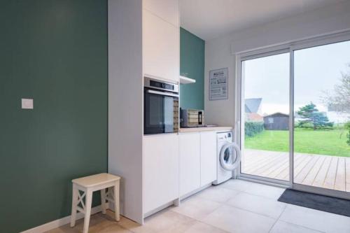 eine Küche mit Waschmaschine und Trockner neben einem Fenster in der Unterkunft Ty Glas charmante maison 200 m de la plage in Ploudalmézeau