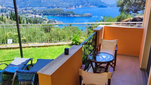 a balcony with chairs and a view of the water at Villa Amaryllis in Paleokastritsa