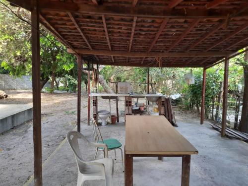 drewniany stół i dwa krzesła pod pawilonem w obiekcie EcoCamp TV Cristã Web w mieście Cabo de Santo Agostinho