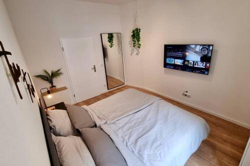 a bedroom with a bed and a tv on the wall at Stylisches Apartment in zentraler Lage mit Balkon in Karlsruhe