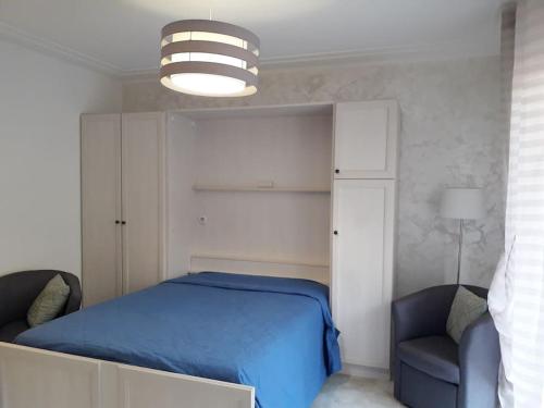 - une chambre avec un lit bleu et une chaise dans l'établissement Studio centre ville entièrement rénové au calme, à Menton
