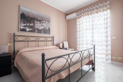 - une chambre avec un lit et une photo sur le mur dans l'établissement Apartment Castle, à Milazzo