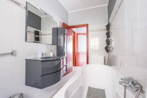La salle de bains est pourvue d'une baignoire blanche et d'un lavabo. dans l'établissement Apartment Castle, à Milazzo