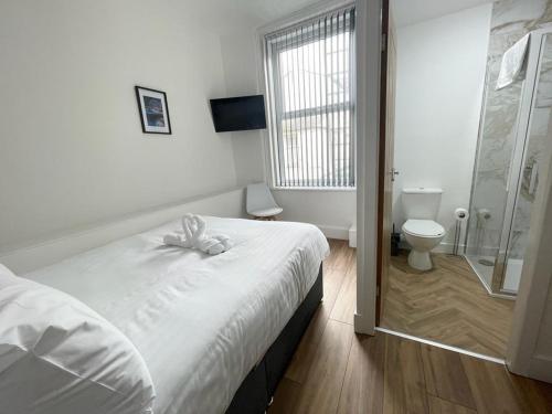 a bedroom with a bed and a shower and a toilet at Beach House By Sasco in Blackpool