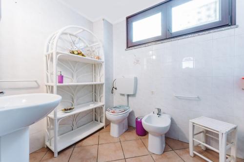 uma casa de banho branca com um WC e um lavatório em Casa vacanze G e B Sardegna em Capitana