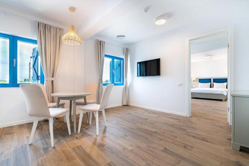 a dining room with a table and chairs and a bedroom at Pensiunea Terrablue in Sulina