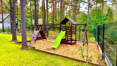 a playground with a green slide and a slideintend at Domek na Jurze in Kroczyce